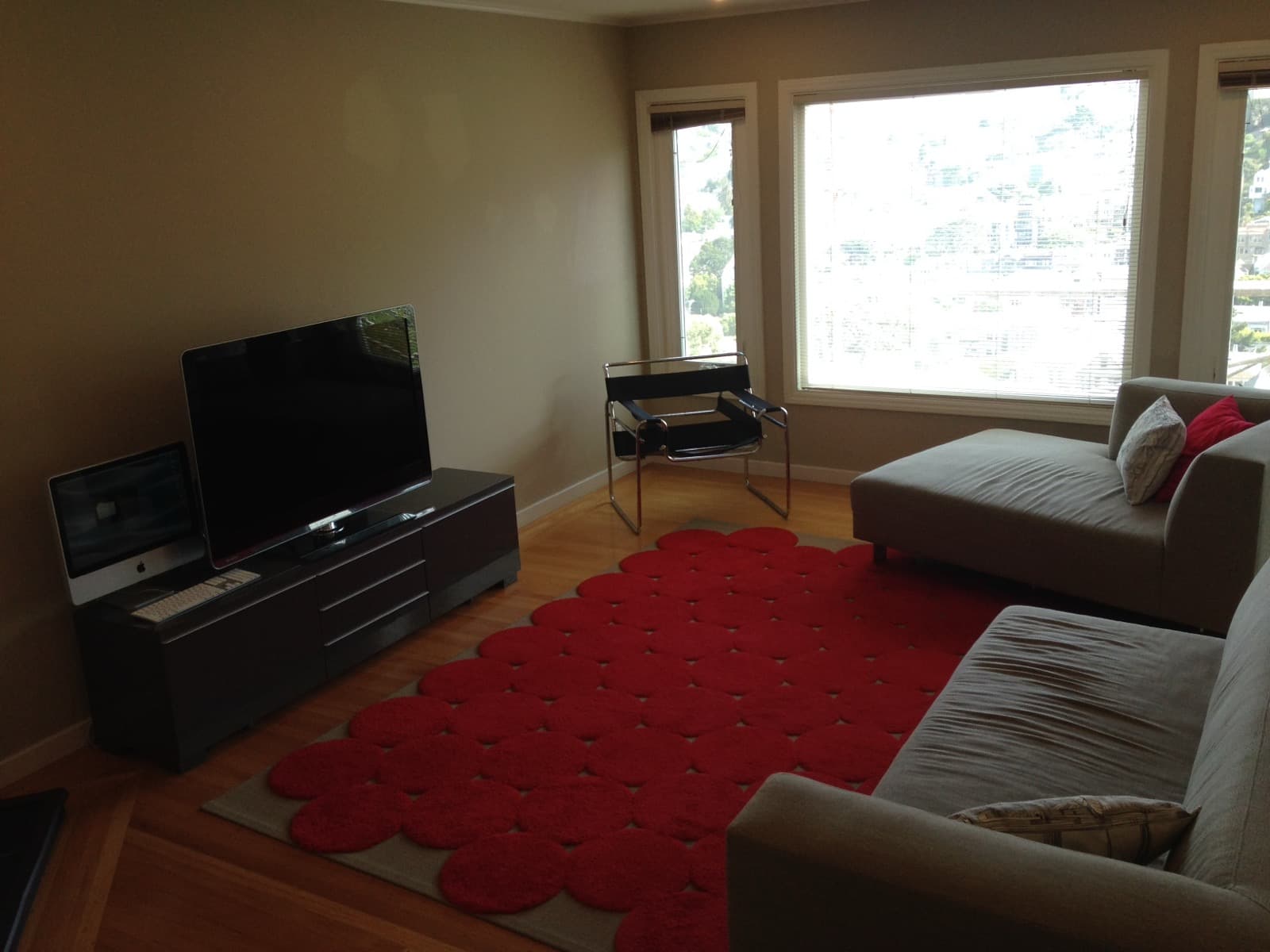 Corona Heights home living room in July 2014: wood-trimmed windows, crown molding, beige walls, oak floors and a grey sofa